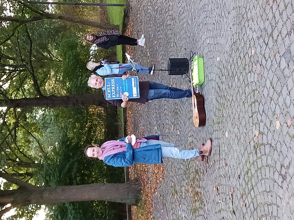 Schulleitung mit Schild vom Schulexpress.