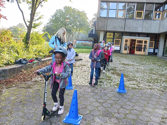 Kinder mit fahren mit Rollern.