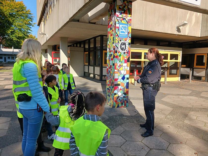 Schülerinnen und Schüler mit Polizistin.