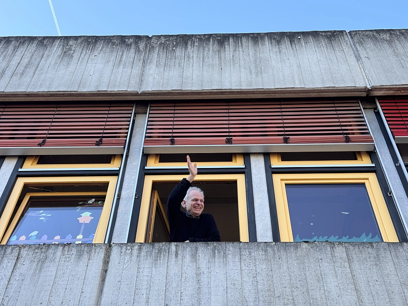 Herr Leimbach winkt aus einem Fenster