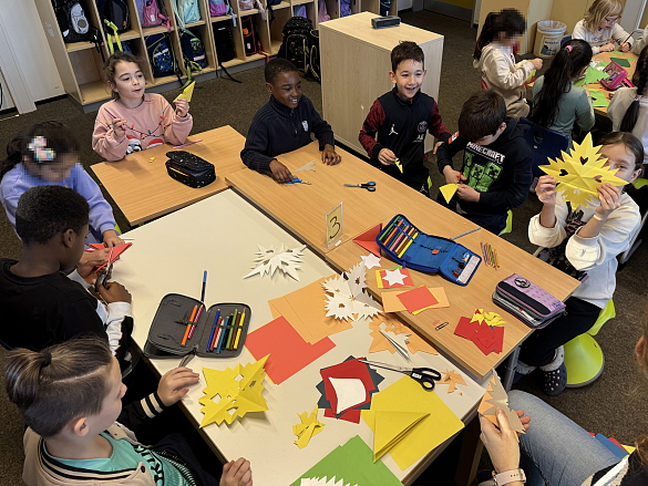 Kinder fertigen Scherenschnitt-Sterne an