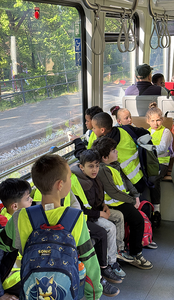 Schüler:innen und Lehrkräfte fahren mit der Straßenbahn