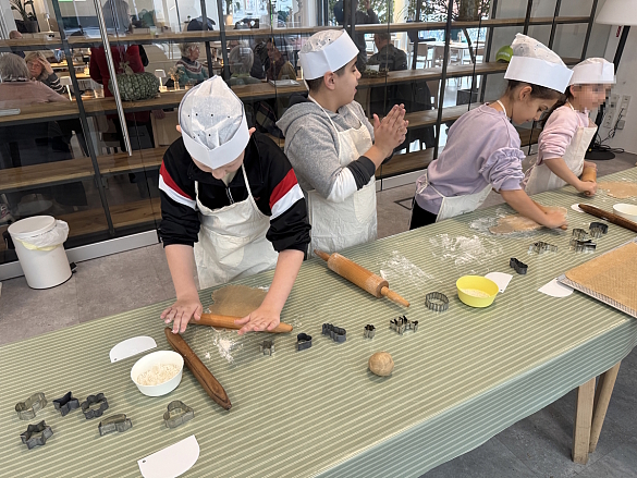 Schülerinnen und Schüler rollen den Teig aus