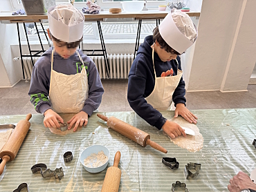 Schülerinnen und Schüler stechen mit Formen Plätzchen aus