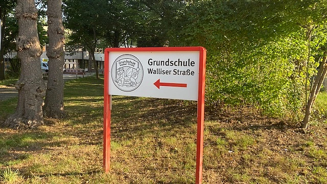 Schild mit Logo zur Grundschule Walliser Straße.