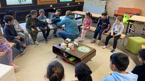 Kinder sitzen im Kreis.