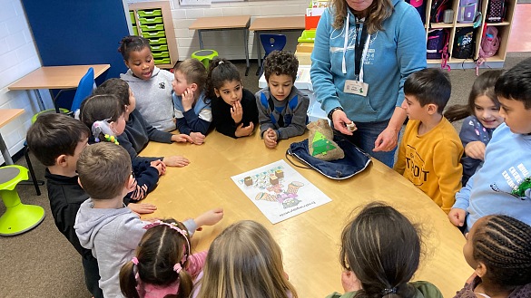Kinder um einem Tisch spielen ein Lernspiel.
