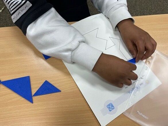 Ein Kind legt Tangram-Formen