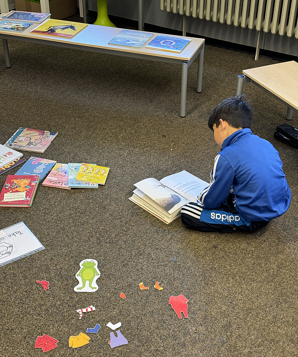 Ein Schüler liest ein Bilderbuch