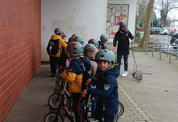 Die Kinder schließen ihre Roller gemeinsam an