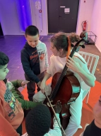 Schüler:innen dürfen auf einem Cello spielen und die Schwingungen der Töne spüren