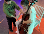 Schüler:innen dürfen auf einem Cello spielen und die Schwingungen der Töne spüren