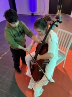 Schüler:innen dürfen auf einem Cello spielen und die Schwingungen der Töne spüren
