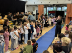 Schülerinnen und Schüler singen und musizieren in der Aula der GSO
