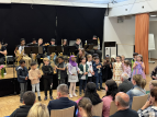 Schülerinnen und Schüler singen und musizieren in der Aula der GSO
