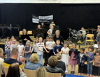 Schülerinnen und Schüler singen und musizieren in der Aula der GSO