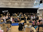 Schülerinnen und Schüler singen und musizieren in der Aula der GSO