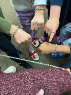 Kinder zeigen ihre gebastelten Armbänder